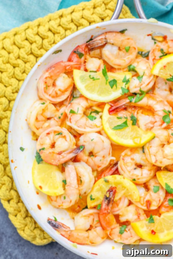 Sizzling Lemon Garlic Shrimp 2 Delicious skillet shrimp garnished with fresh lemon wedges, ready to serve.