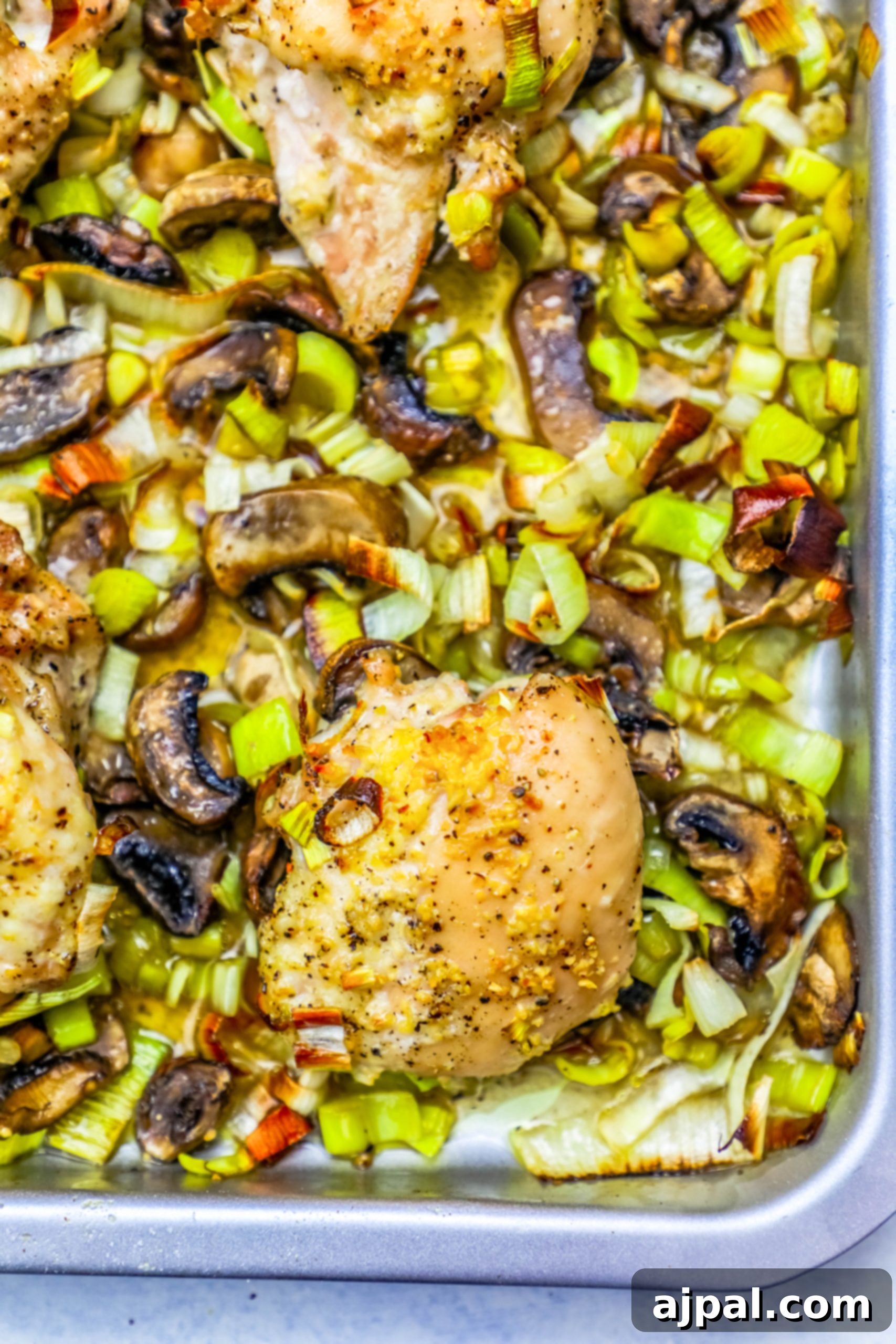Sheet pan roasted chicken with leeks and mushrooms A sheet pan filled with perfectly roasted chicken, caramelized leeks, and tender mushrooms, fresh out of the oven.