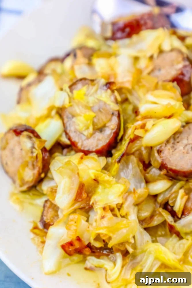 picture of sausage, onions, and cabbage sautéed in a pan