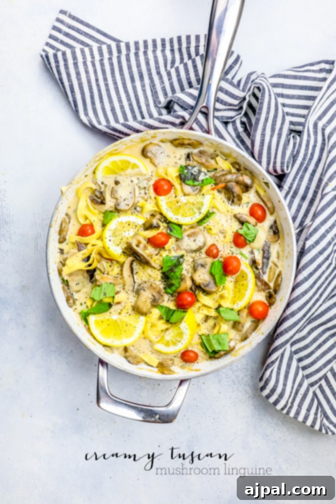Silky One-Pot Tuscan Mushroom Linguine 2 Creamy Tuscan Mushroom Linguine in a pan, garnished with fresh basil, cherry tomatoes, and lemon slices.