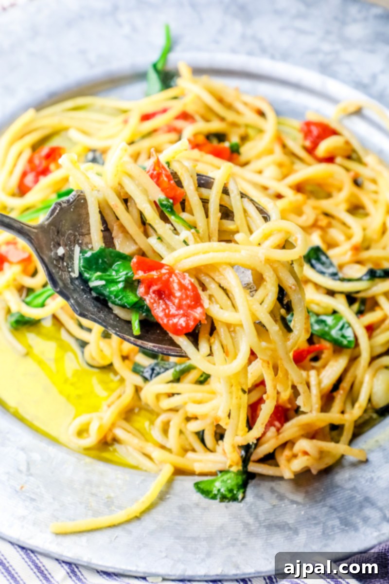 Garlic Butter Spinach Parmesan Spaghetti 4 A vibrant bowl of Spinach Parmesan Garlic Butter Spaghetti, garnished with fresh basil leaves, ready to be enjoyed.