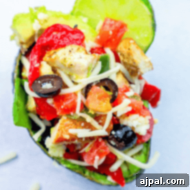 Loaded Cheesy Chicken Taco Salad Avocado Boats 8 A halved avocado filled with diced chicken, chopped tomatoes, sliced olives, shredded cheese, and a wedge of lime creates a delicious keto chicken taco avocado.