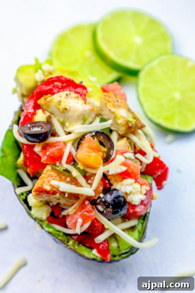 Loaded Cheesy Chicken Taco Salad Avocado Boats 3 Keto-friendly stuffed avocado with chicken, tomatoes, and cheese.
