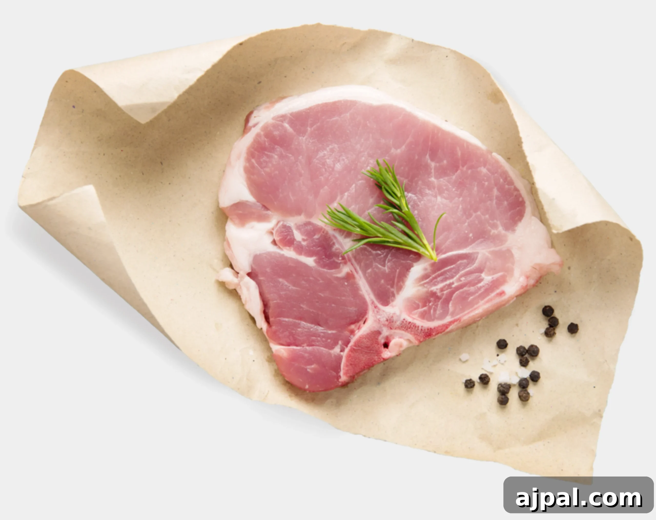 A center-cut pork loin chop with a prominent T-bone, served on parchment paper.