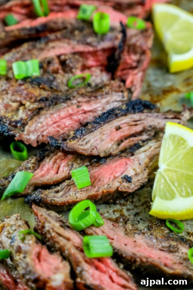 Mastering Grilled Flank Steak 3 Perfectly grilled flank steak on a baking sheet, garnished with fresh lemon slices, highlighting its savory appeal.