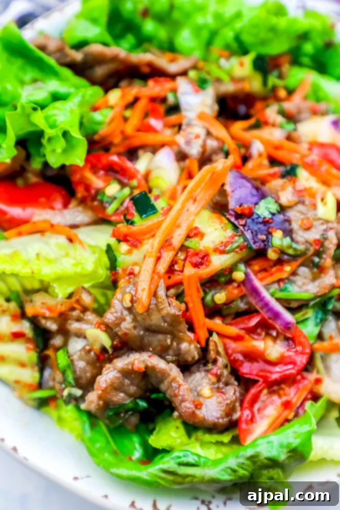 Fiery Thai Beef Salad 3 A close-up of a spicy beef salad with a mix of fresh vegetables like lettuce and carrots, showcasing its vibrant colors and textures, perfect for a keto diet.