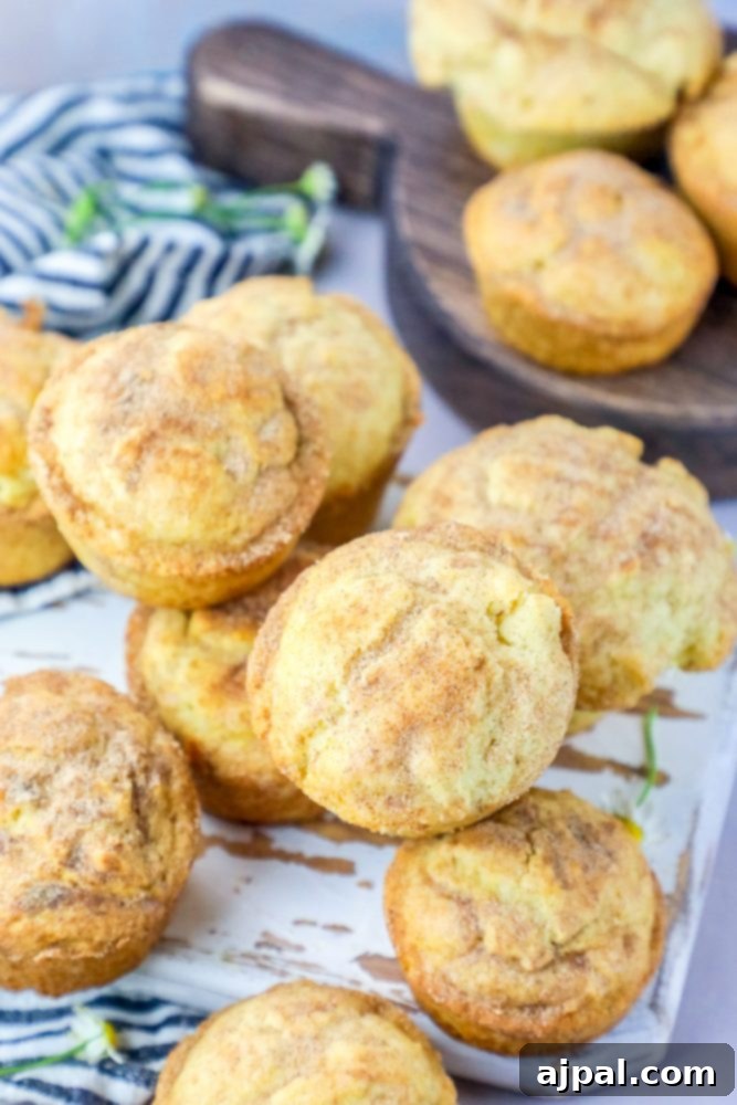 A beautifully arranged platter of snickerdoodle muffins, freshly baked and dusted with cinnamon sugar, ready to be served.