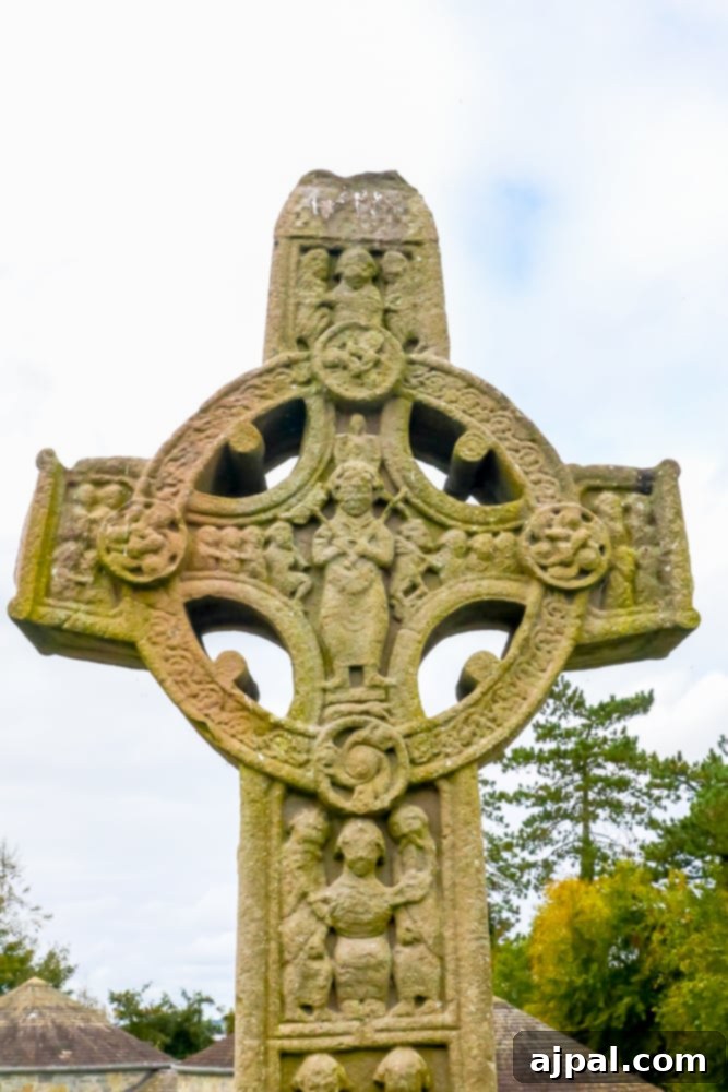 A historic stone cross situated in the scenic landscape of Ireland’s Midlands at Clonmacnoise.