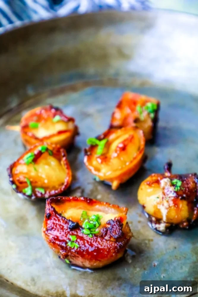 A simple plate featuring a few perfectly cooked brown sugar bacon wrapped scallops, highlighting their crispy bacon and glistening glaze