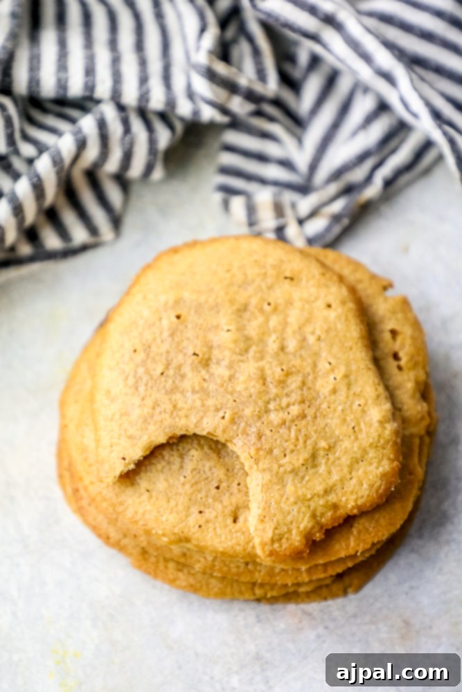 No-Fuss Keto Peanut Butter Cookies 3 Stack of freshly baked keto peanut butter cookies with a bite taken out of the top one.