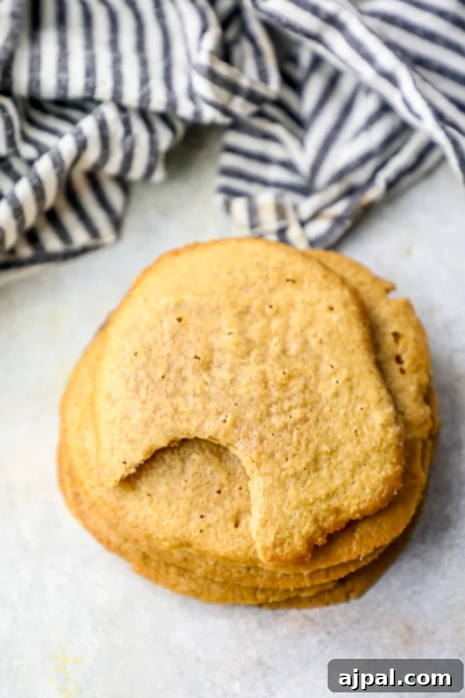 Effortless Keto Peanut Butter Cookies 3 A stack of soft keto peanut butter cookies with a bite taken out of the top one.