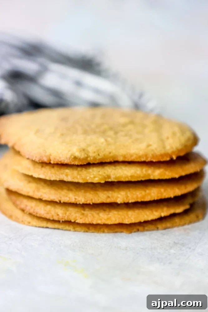 No-Fuss Keto Peanut Butter Cookies 5 Stack of freshly baked keto peanut butter cookies with a bite taken out of the top one.
