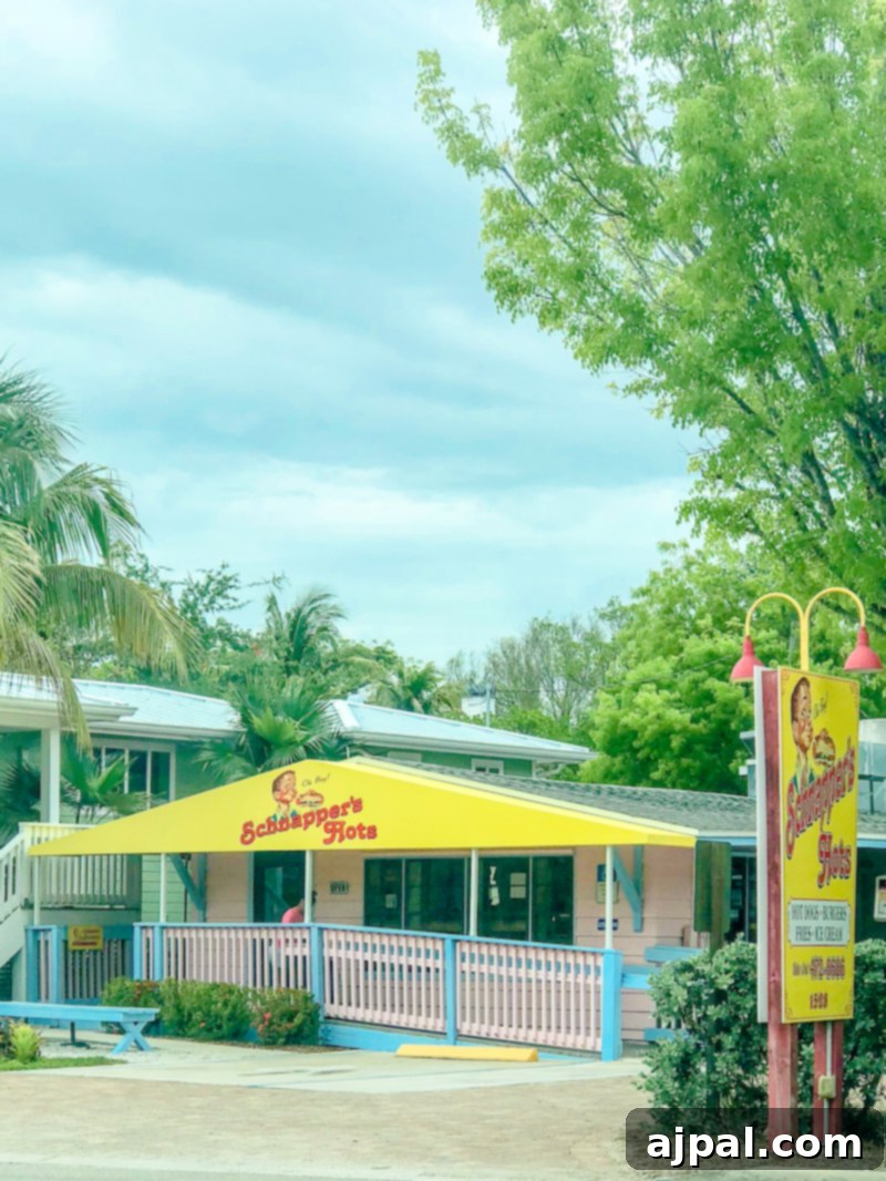 Savor Sanibel: A Culinary Journey 13 A vibrant pink and yellow restaurant adorned with palm trees in the background serving delicious food on Sanibel Island, Florida.