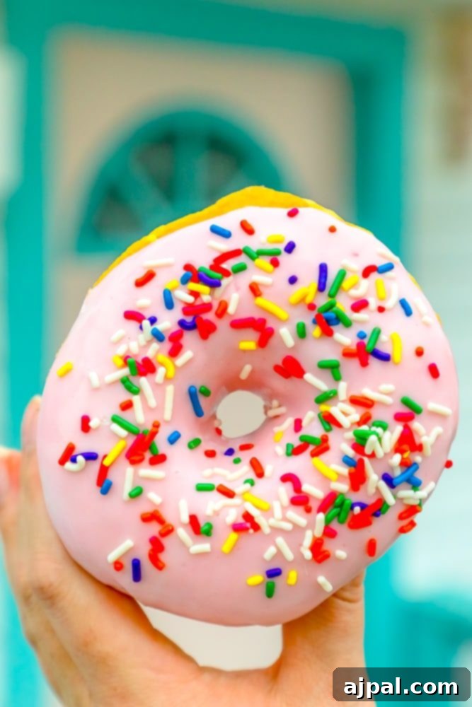 Savor Sanibel: A Culinary Journey 5 A person enjoying the best dessert, a pink donut with sprinkles, on Sanibel Island, Florida.