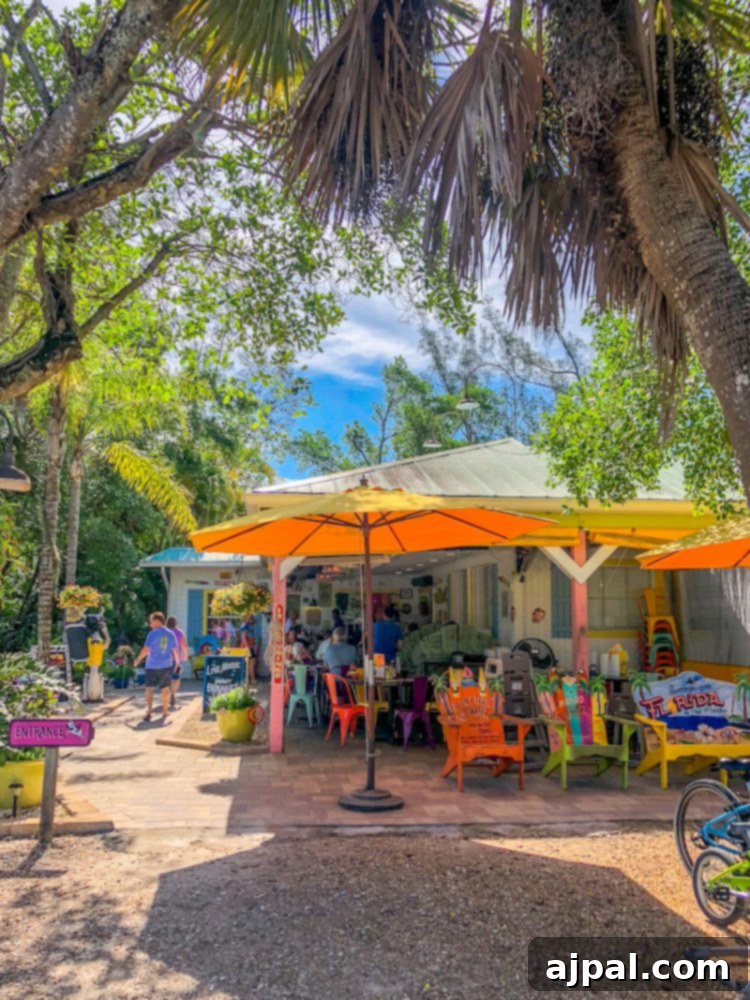 Savor Sanibel: A Culinary Journey 9 A group of people enjoying dinner at tables under umbrellas on Sanibel Island, Florida.