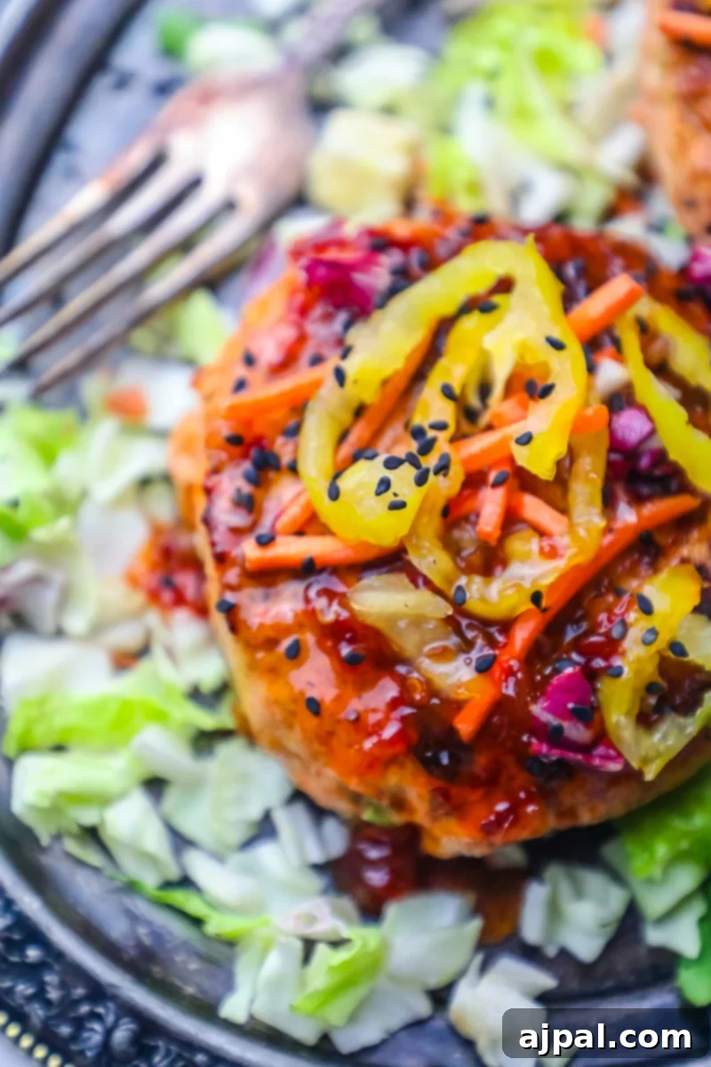Sweet Chili Glazed Asian Salmon Burgers 4 A delicious and colorful plate featuring Spicy Sweet Chili Asian Salmon Burgers, garnished and ready to eat.