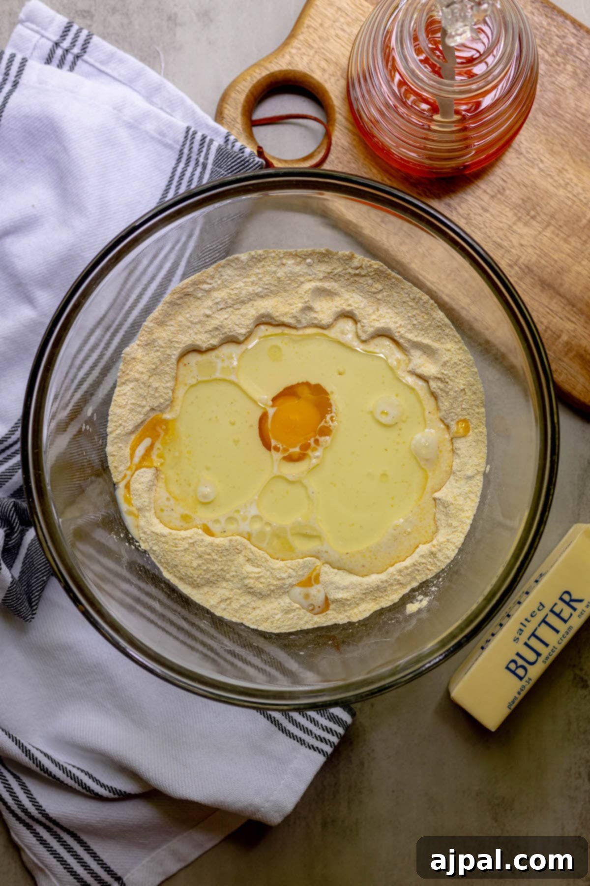 Wet ingredients (butter, sugar, eggs, sour cream, milk) being mixed in a large bowl.