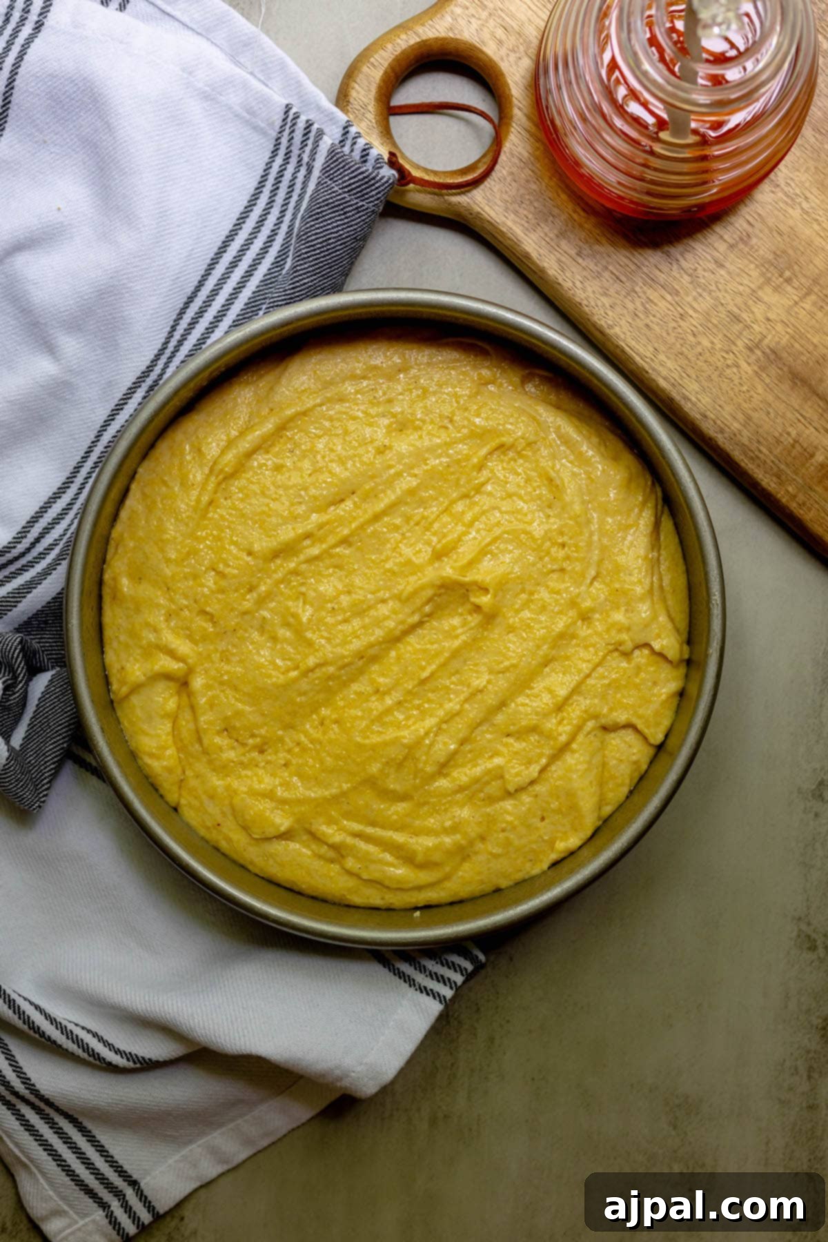 Cornbread batter poured into a greased pan, ready for baking.