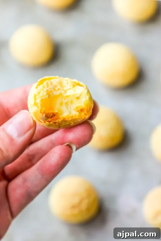 Easy Fogo De Chao Style Brazilian Cheese Bread 2 A person’s hand holding a small piece of dough for making Brazilian Cheese Bread Rolls.