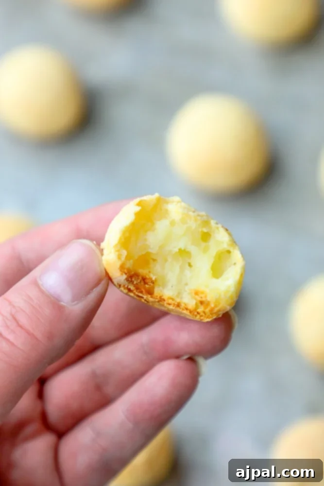 Easy Fogo De Chao Style Brazilian Cheese Bread 3 A person’s hand holding a piece of Brazilian Cheese Bread Rolls.