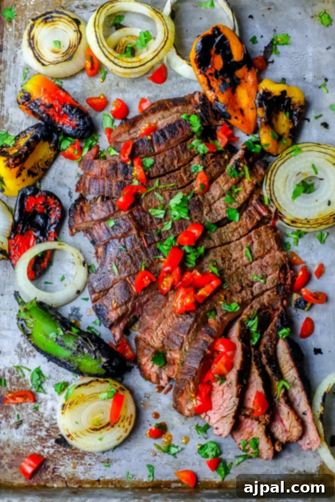 Ultimate Carne Asada 3 Grilled steak fajitas featuring vibrant peppers and onions beautifully arranged on a baking sheet, showcasing a delicious and easy recipe for a satisfying meal.