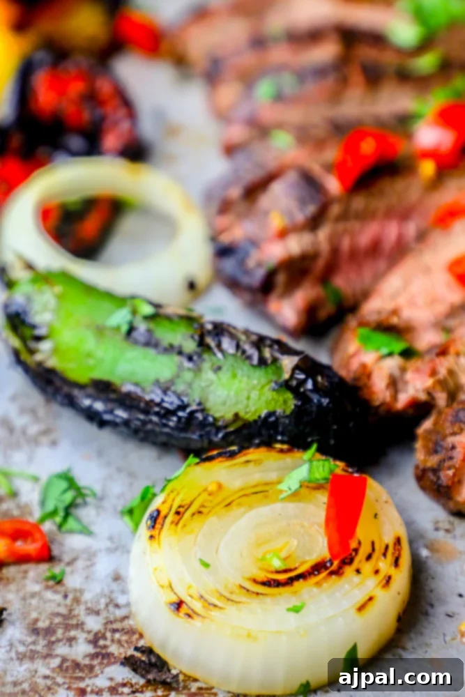 Ultimate Carne Asada 6 Close-up of perfectly charred onions and jalapeños on a grill, ideal for complementing an authentic grilled carne asada steak fajita recipe.