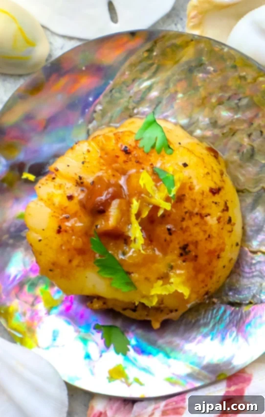 An irresistible plate of pan-seared scallops with a delectable garlic butter sauce, served on a shell-shaped plate.