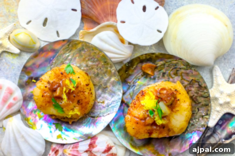 Two exquisitely cooked scallops presented with shells and decorative seashells, infused with garlic butter.