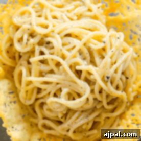 A simple, yet inviting square image of creamy Cacio e Pepe pasta, showcasing its rich texture and signature black pepper flecks.