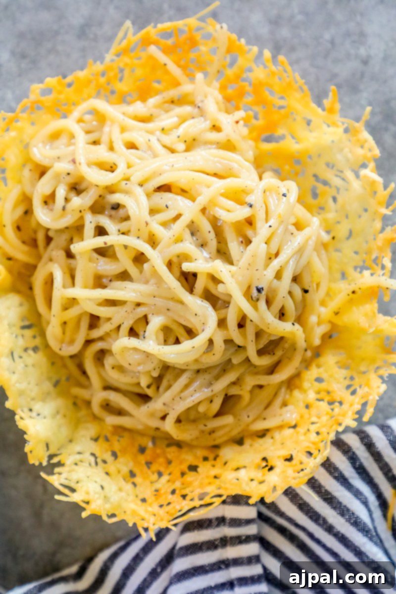 The Best Easy Cacio E Pepe spaghetti recipe elegantly displayed in a bowl, resting on a napkin, highlighting its rustic charm and creamy texture.