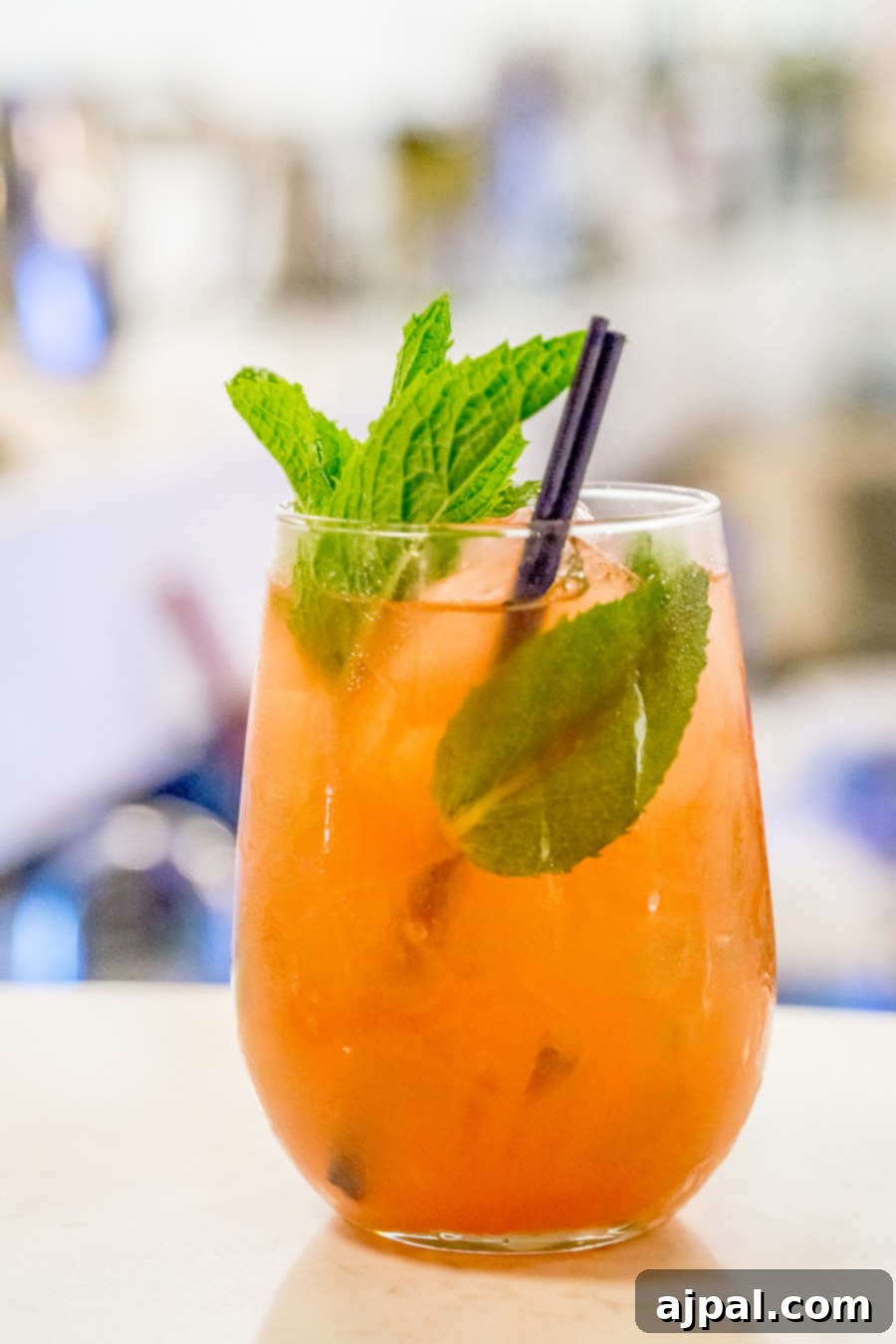 An orange drink with mint leaves in a glass found in Kansas City Missouri.