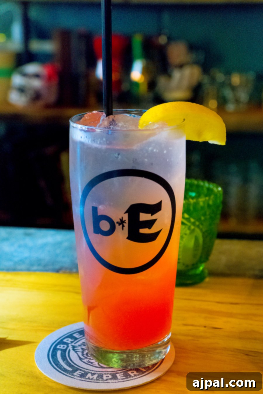 A refreshing drink garnished with a lemon slice served at a wooden bar in Kansas City.