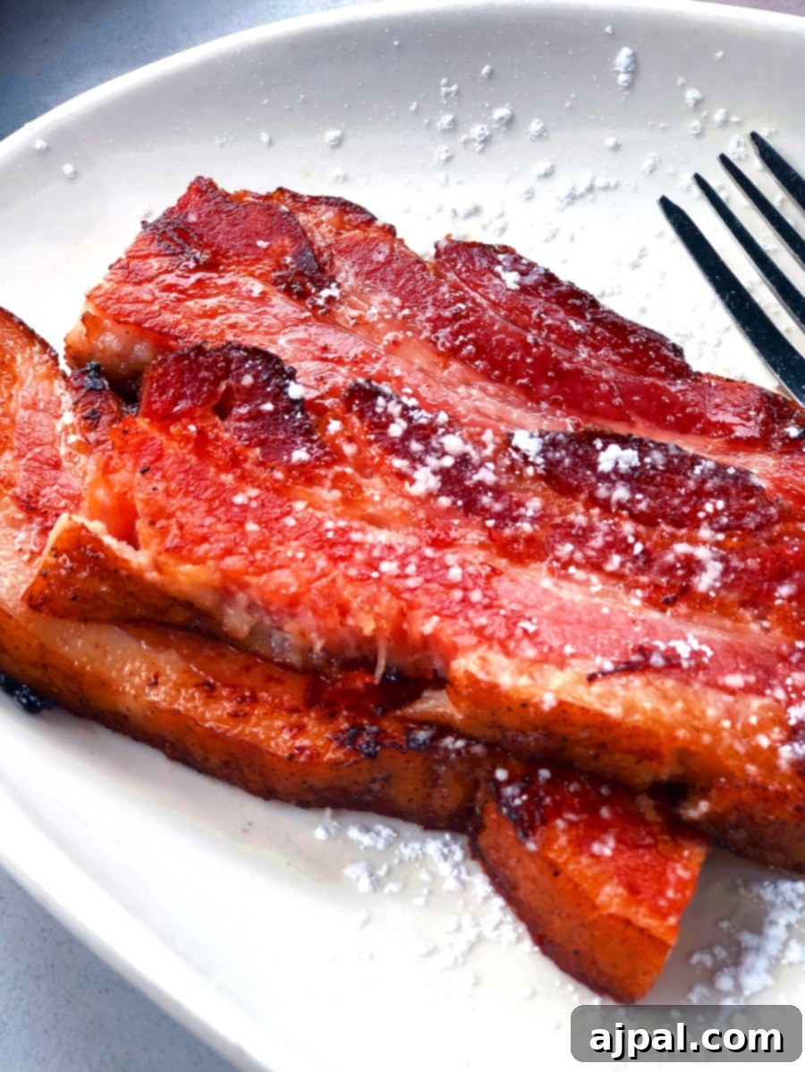 Delicious french toast topped with crispy bacon and a dusting of powdered sugar.