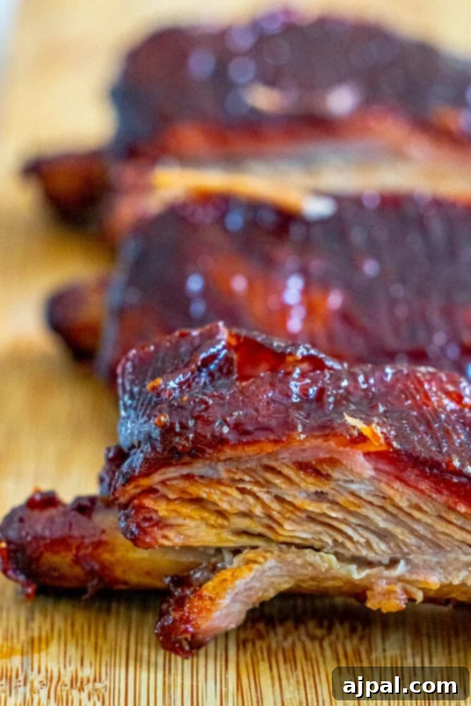 Smoked pork ribs showcased on a wooden cutting board following the 3-2-1 Smoked Ribs method, highlighting the succulent meat and crispy exterior.