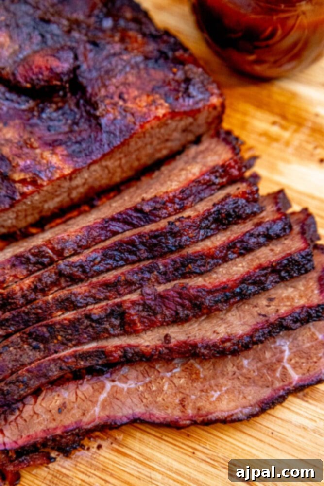 Perfectly sliced smoked brisket resting on a rustic wooden cutting board, showcasing its tender texture and delicious bark.
