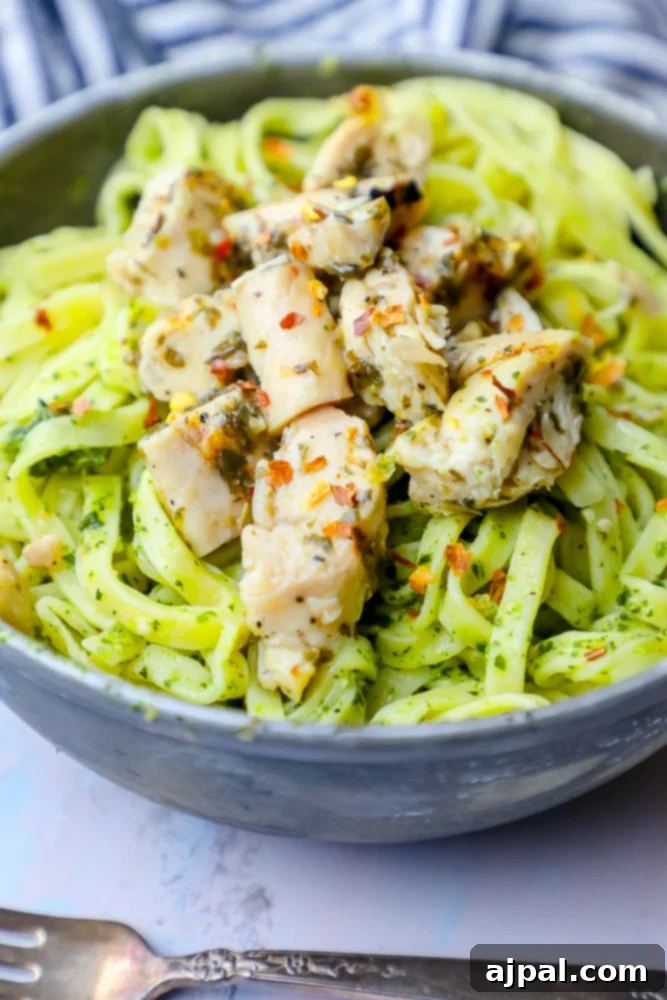 A hearty serving of chimichurri chicken pasta in a white bowl, showcasing the rich green sauce and tender chicken pieces.
