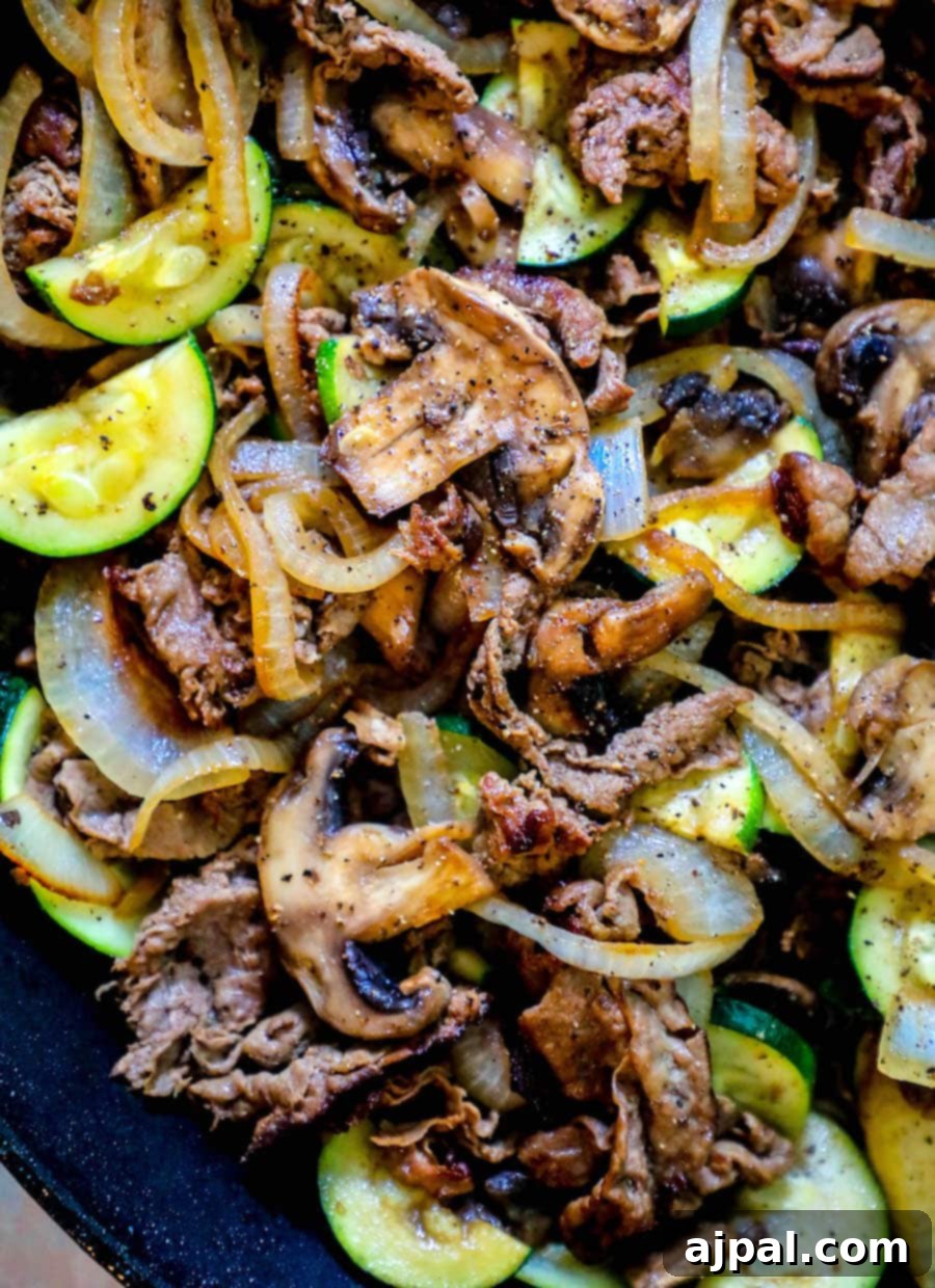 One-Pan Sirloin and Veggies Dinner 3 A skillet filled with zucchini and onions cooked alongside thin sliced top sirloin for a delicious dinner.