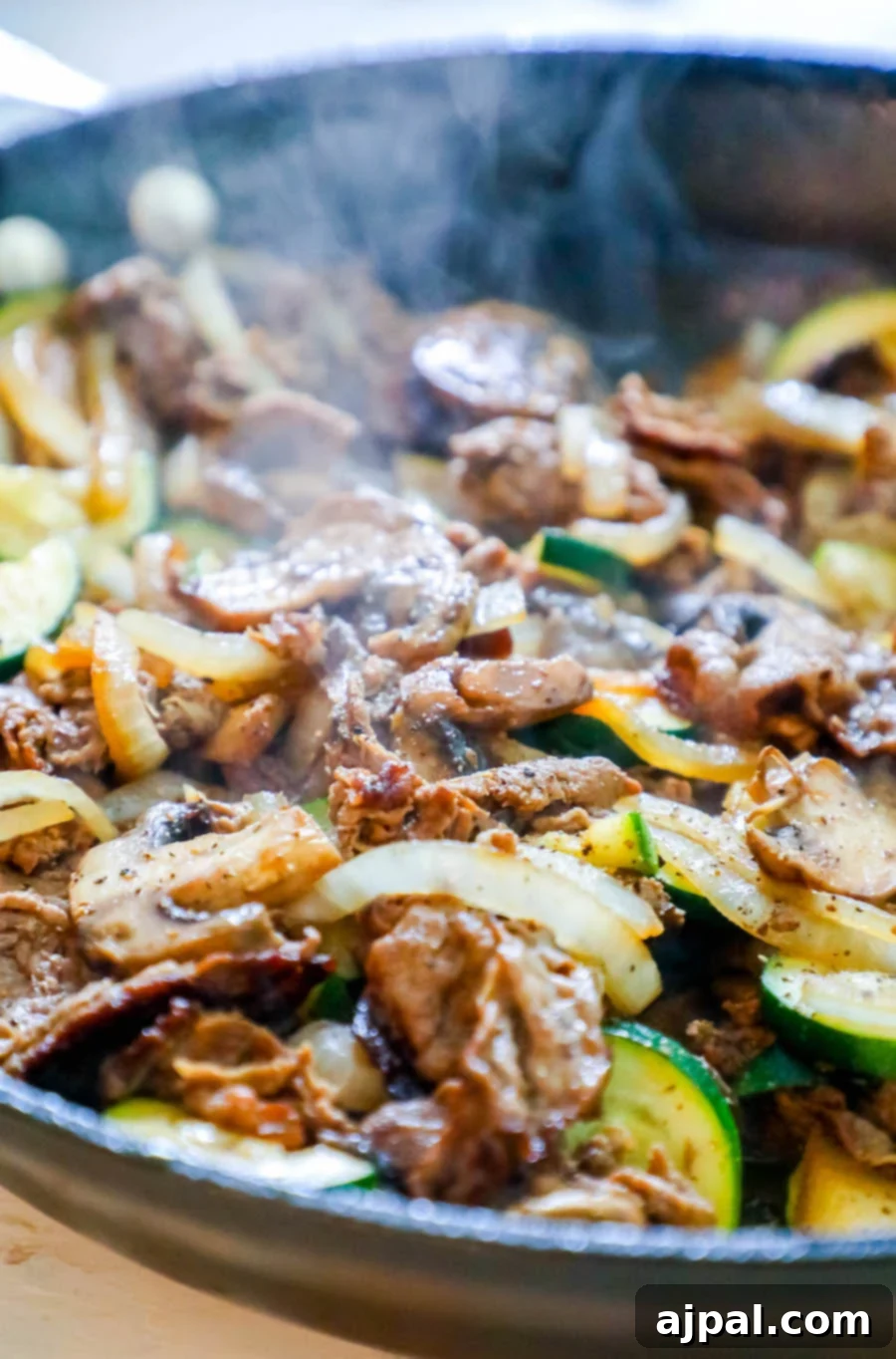 One-Pan Sirloin and Veggies Dinner 4 Thin-sliced sirloin steak with onions, mushrooms, and zucchini, perfectly cooked and ready to enjoy.