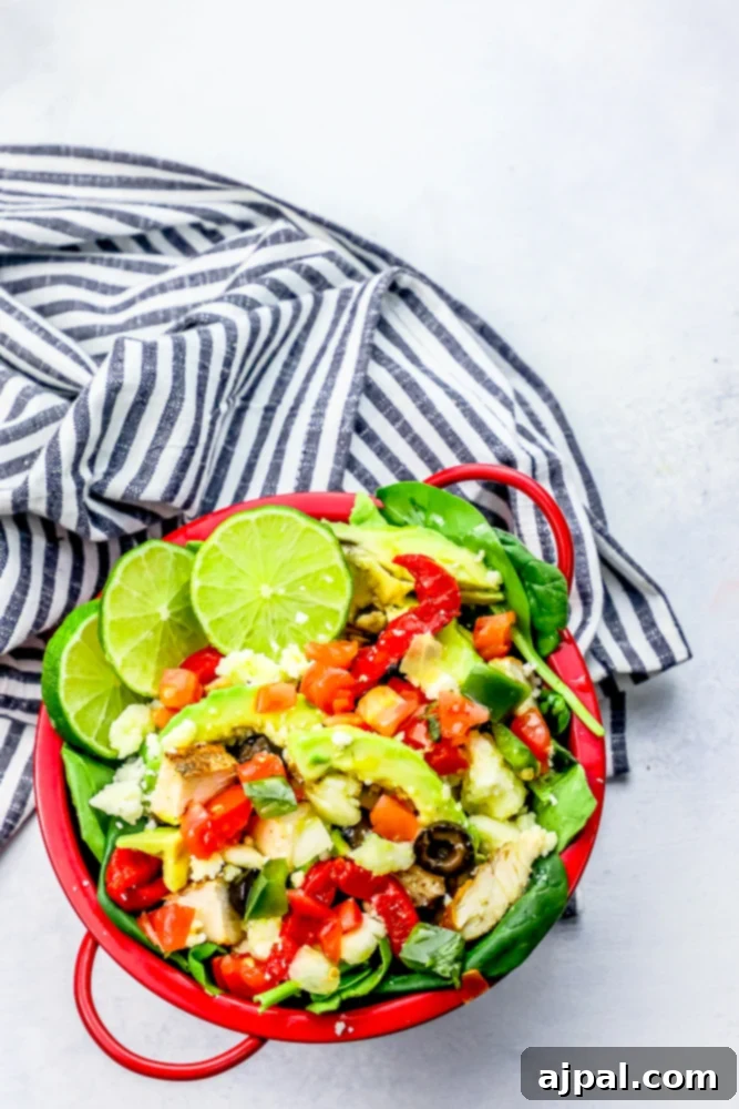 Quick and Delicious Chicken Taco Salad 3 A close-up shot of a vibrant chicken taco salad presented in a red bowl, highlighting the colorful medley of ingredients.