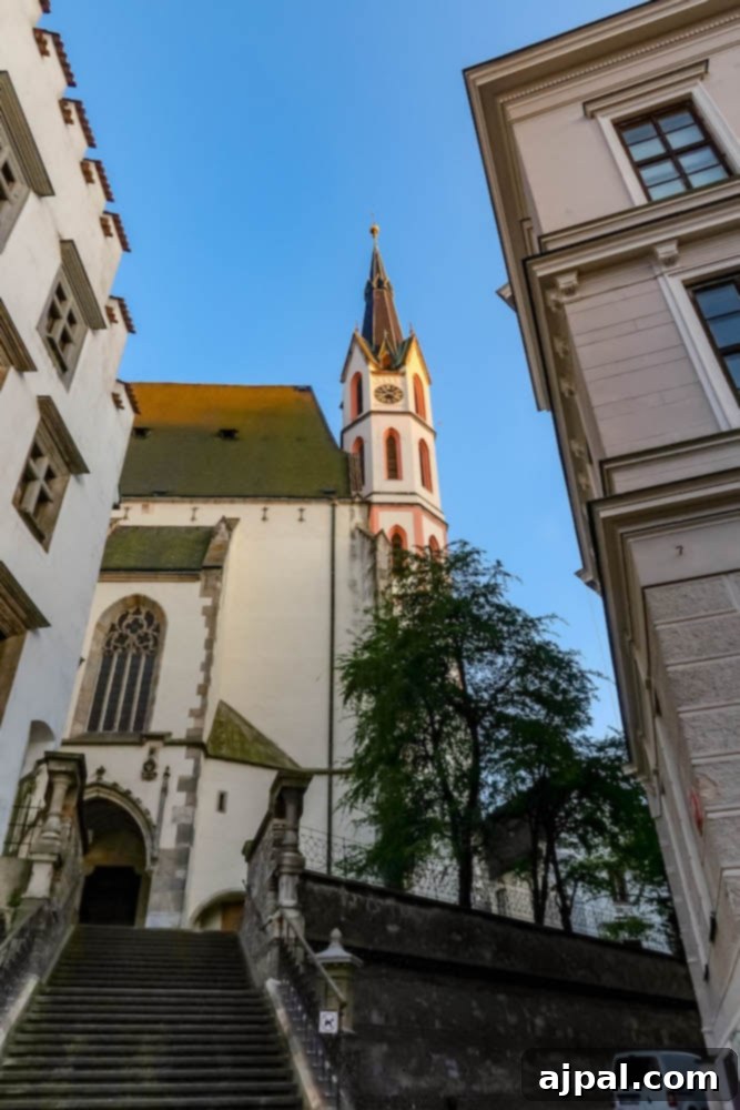St. Vitus Church in Cesky Krumlov, a stunning Gothic structure with a tall spire, rising above the historic town buildings.
