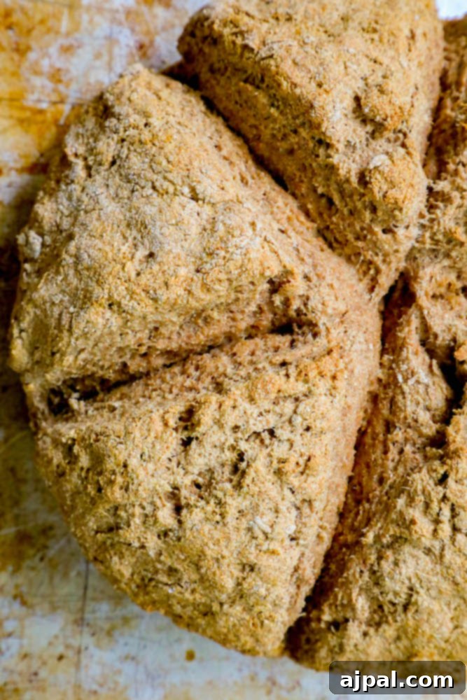 A rustic loaf of freshly baked Irish soda bread, expertly sliced and presented on a wooden cutting board.