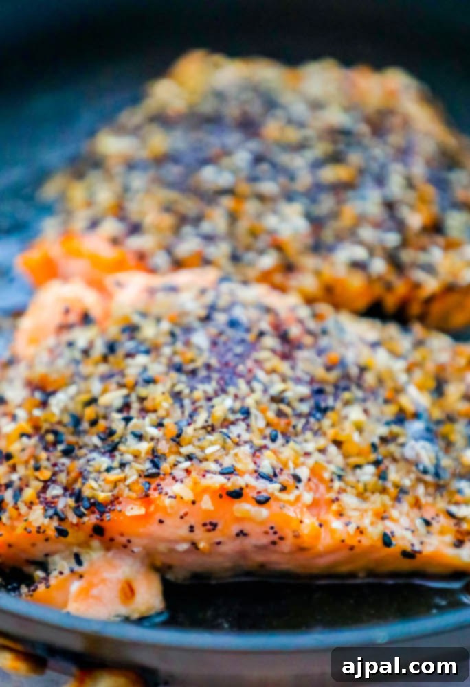 Close-up of a salmon fillet covered in everything bagel seasoning, showing the texture and seasoning details.