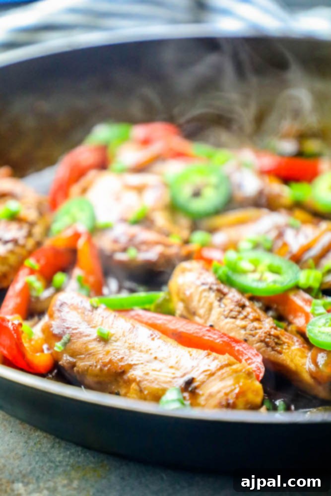 chicken, onions, peppers, and jalapenos in cooking in a pan together