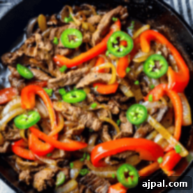 Ultimate One-Pan Steak Fajitas 7 A skillet filled with cooked beef strips, red bell peppers, onions, and sliced green jalapenos creates the perfect one pot steak fajitas.