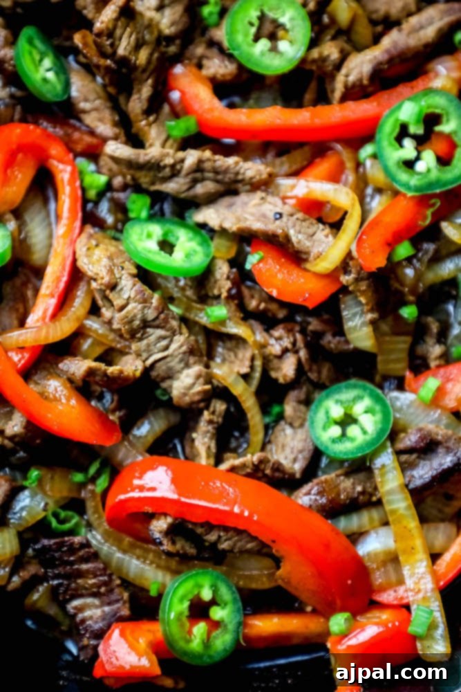 Ultimate One-Pan Steak Fajitas 3 Close-up of perfectly cooked steak fajitas with peppers and onions in a cast iron skillet