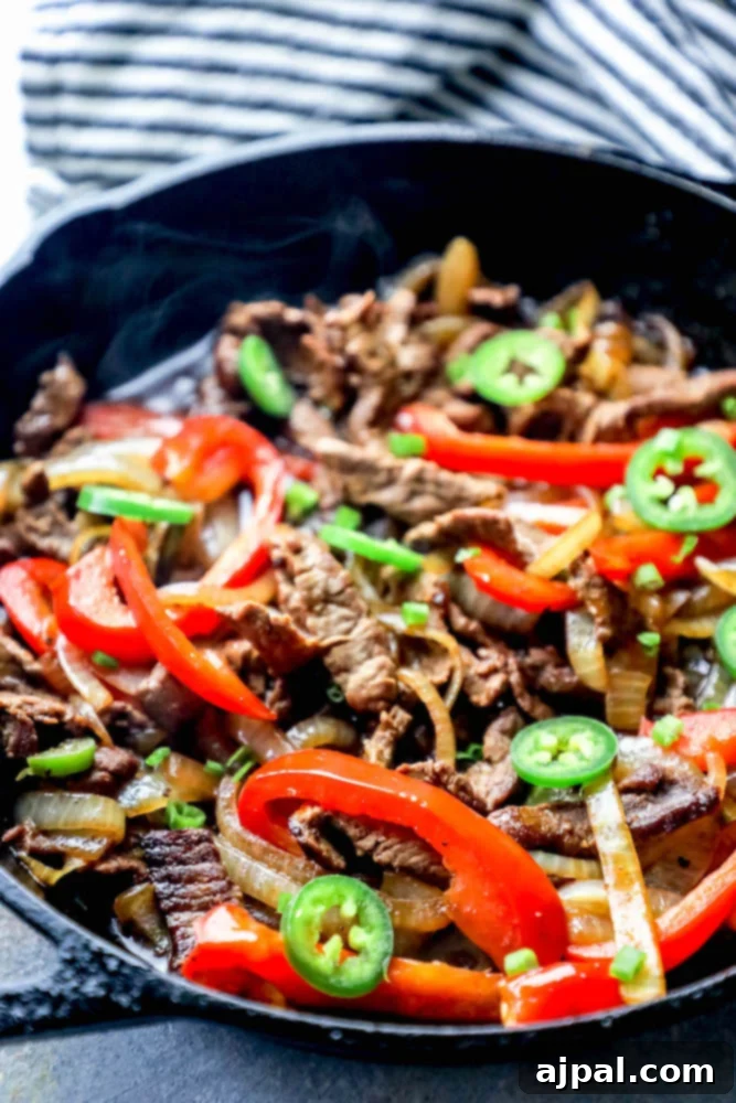 Ultimate One-Pan Steak Fajitas 4 One pot steak fajitas cooking in a cast iron pan with vibrant bell peppers and onions