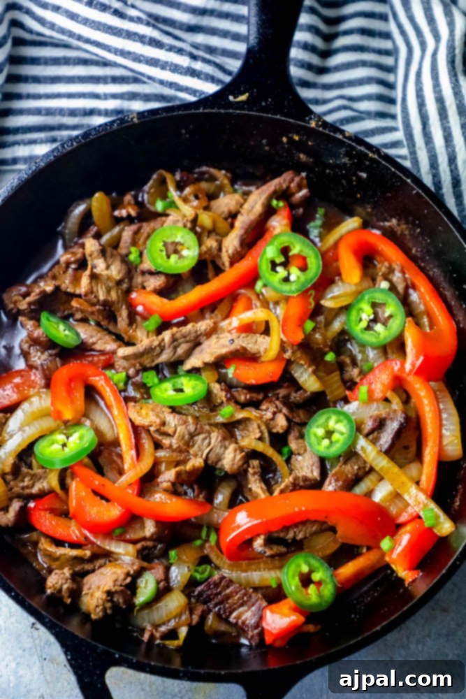 Ultimate One-Pan Steak Fajitas 6 One pot steak fajitas ready to serve in a cast iron skillet with fresh cilantro