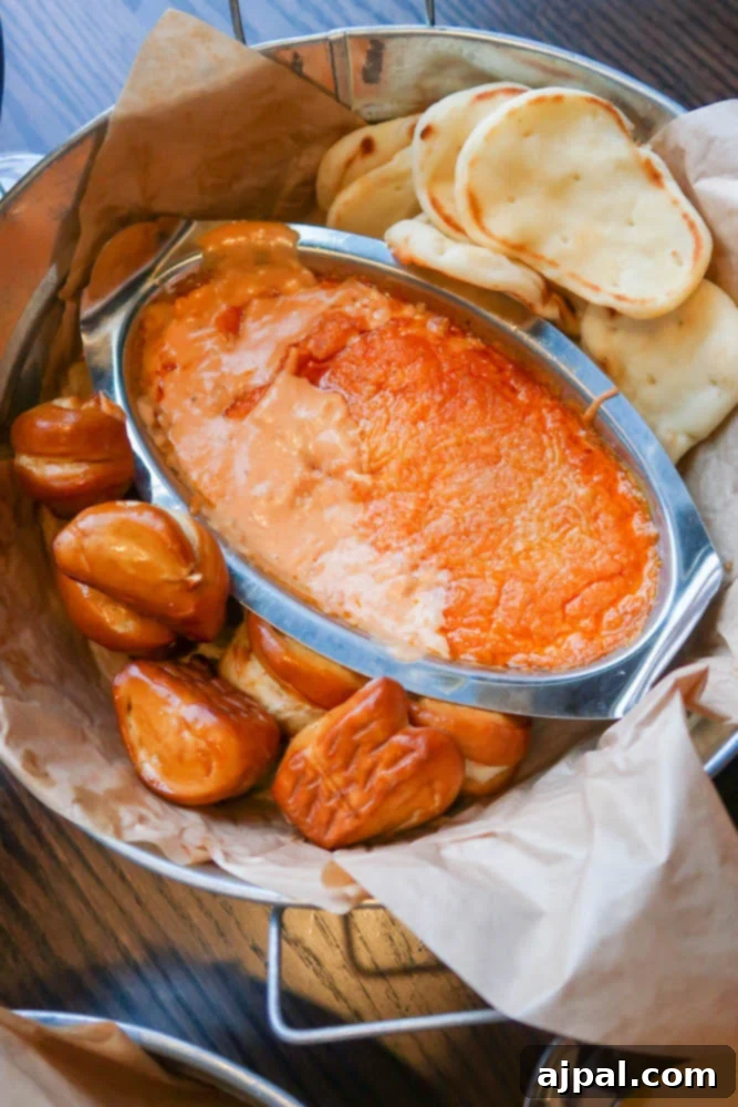A basket overflowing with cheesy shrimp and crab dip, served alongside crisp bread, tantalizing appetites at the Guinness Brewery in Maryland.