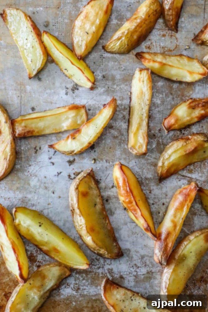Golden Crispy Potato Wedges 4 Oven-baked potato wedges recipe, garnished with herbs and ready to be served.