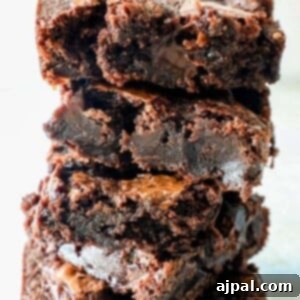 super chocolatey fudge brownies stacked on top of each other on a table
